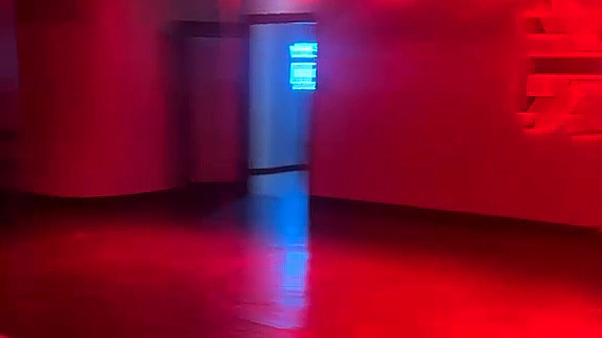 Red-lit Pilates studio at Kinetic Ashfield with blue light glowing through the doorway